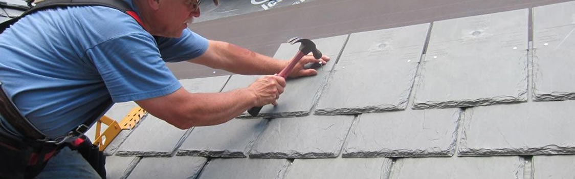 A worker doing a slate roof repair in Pittsburgh, PA